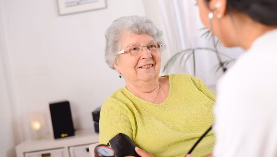 A carer is taking a dementia patient's blood pressure
