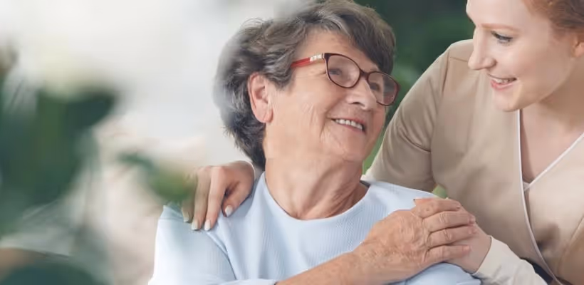 A carer and a dementia patient are holding hands