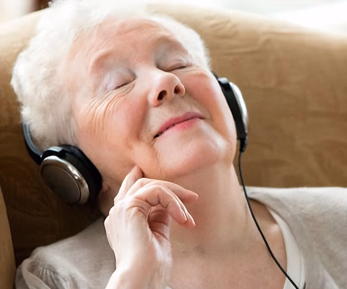 A dementia patient enjoying her music through the headphones