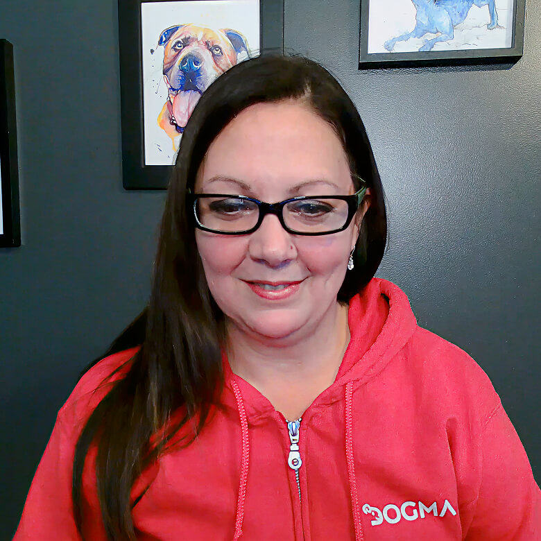 Client Megan wearing a red Bogma hoodie giving a testimonial for Always Beyond IT services with dog paintings in the backg...