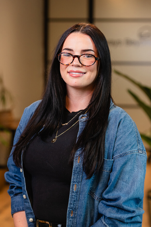 Team member Kennedy wearing a black top and denim jacket at Always Beyond, a Calgary IT services company office.