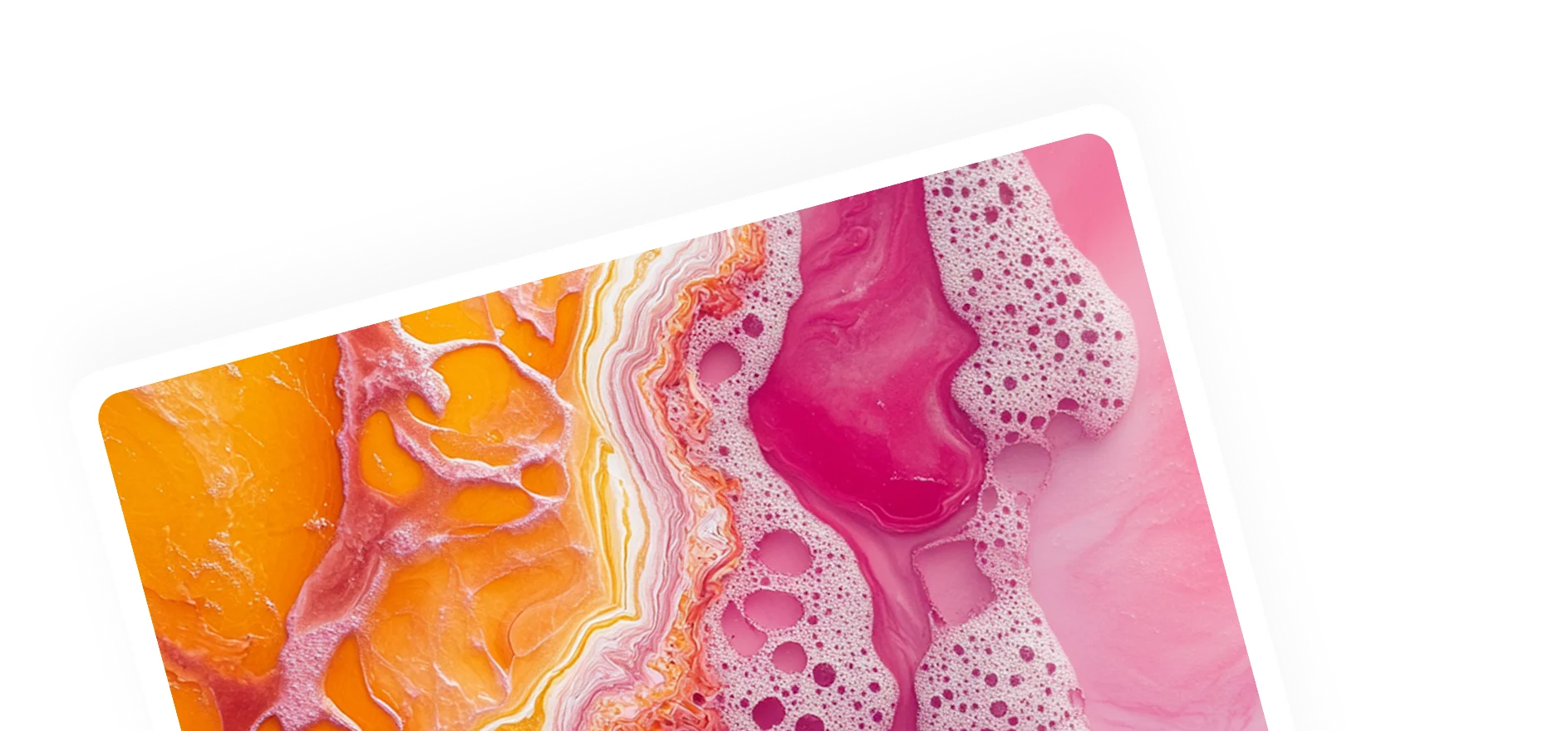 Close-up of vibrant orange and pink marbled resin or paint with frothy bubbles on the pink side.