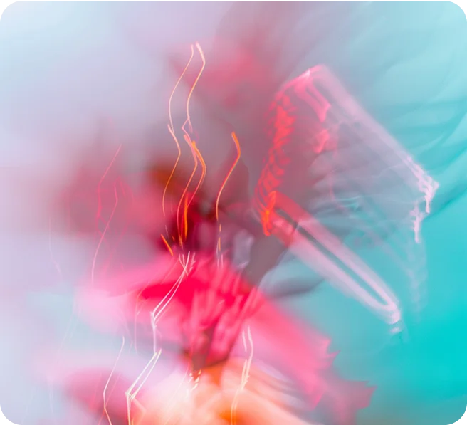 Abstract blurred image with streaks of red, pink, and orange light against a blue background.