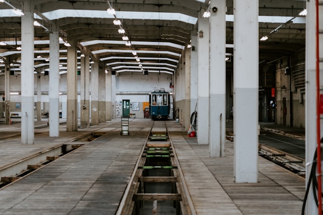 Intérieur d'un ancien dépôt ferroviaire : voies, fosses de visite et tramway ancien