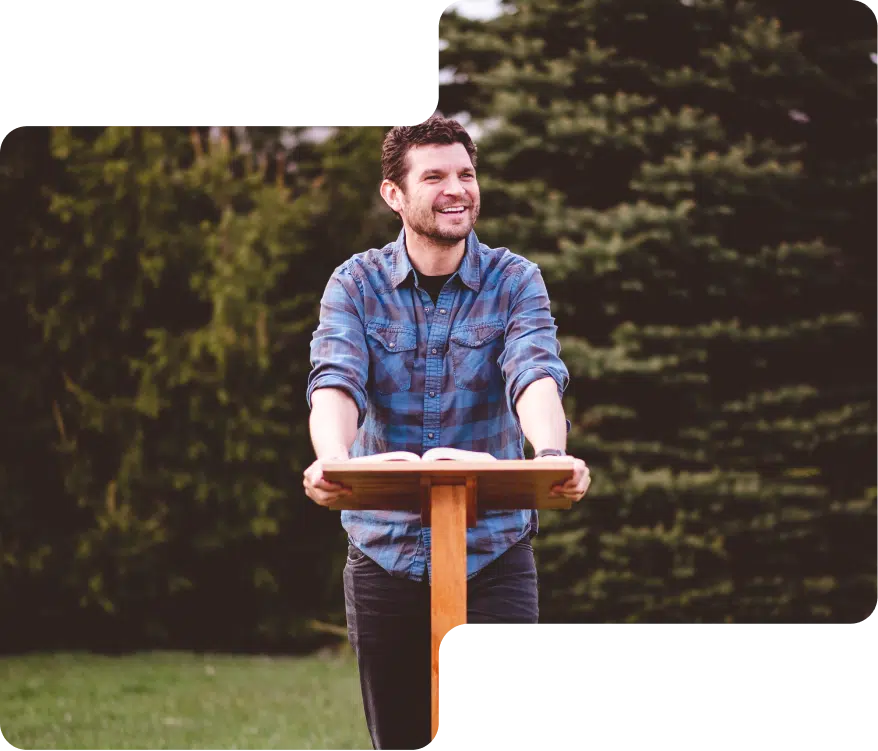 A man speaking from a podium in the garden