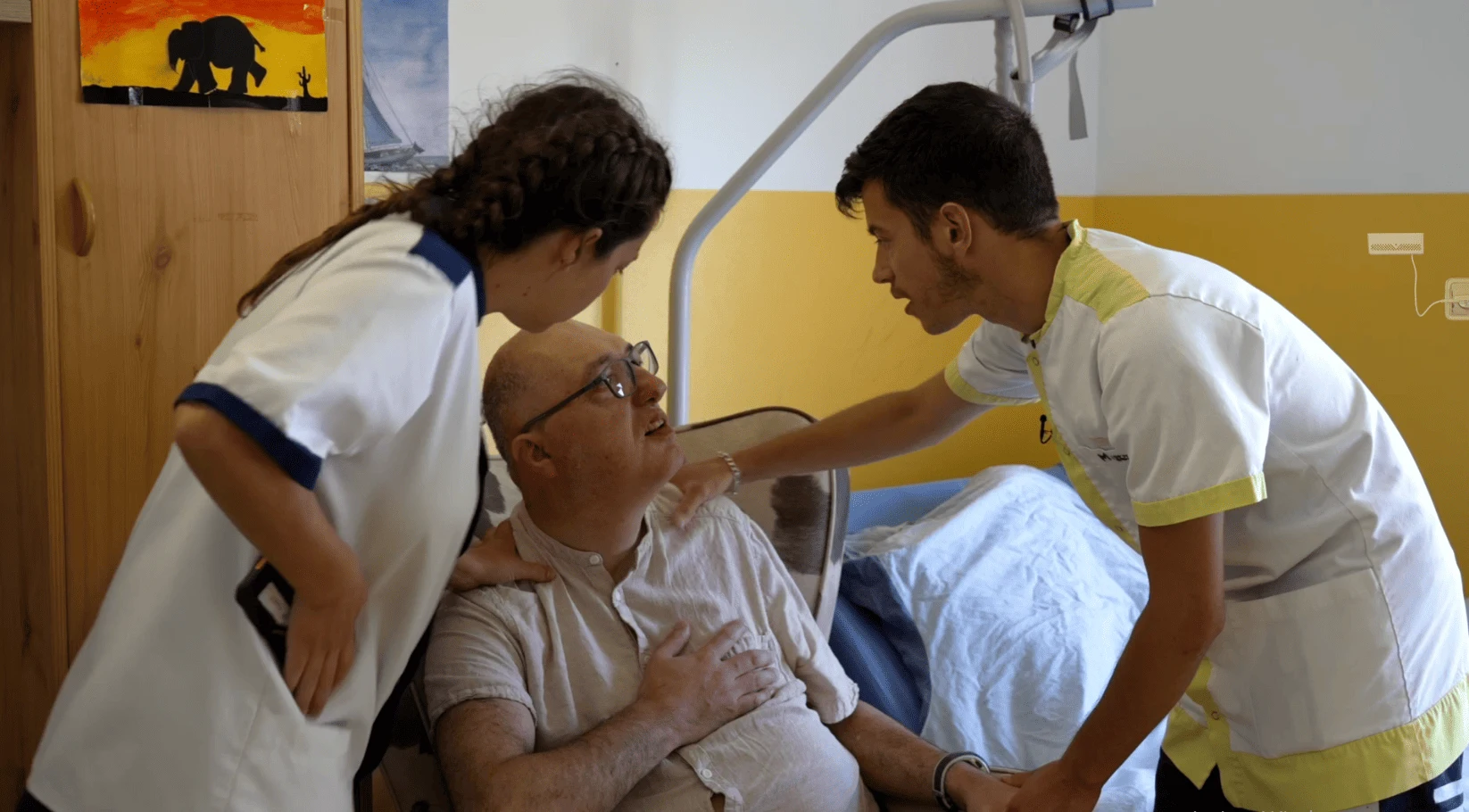 Photo d'un résident en souffrance respiratoire et deux aides soignants en train de l'aider.