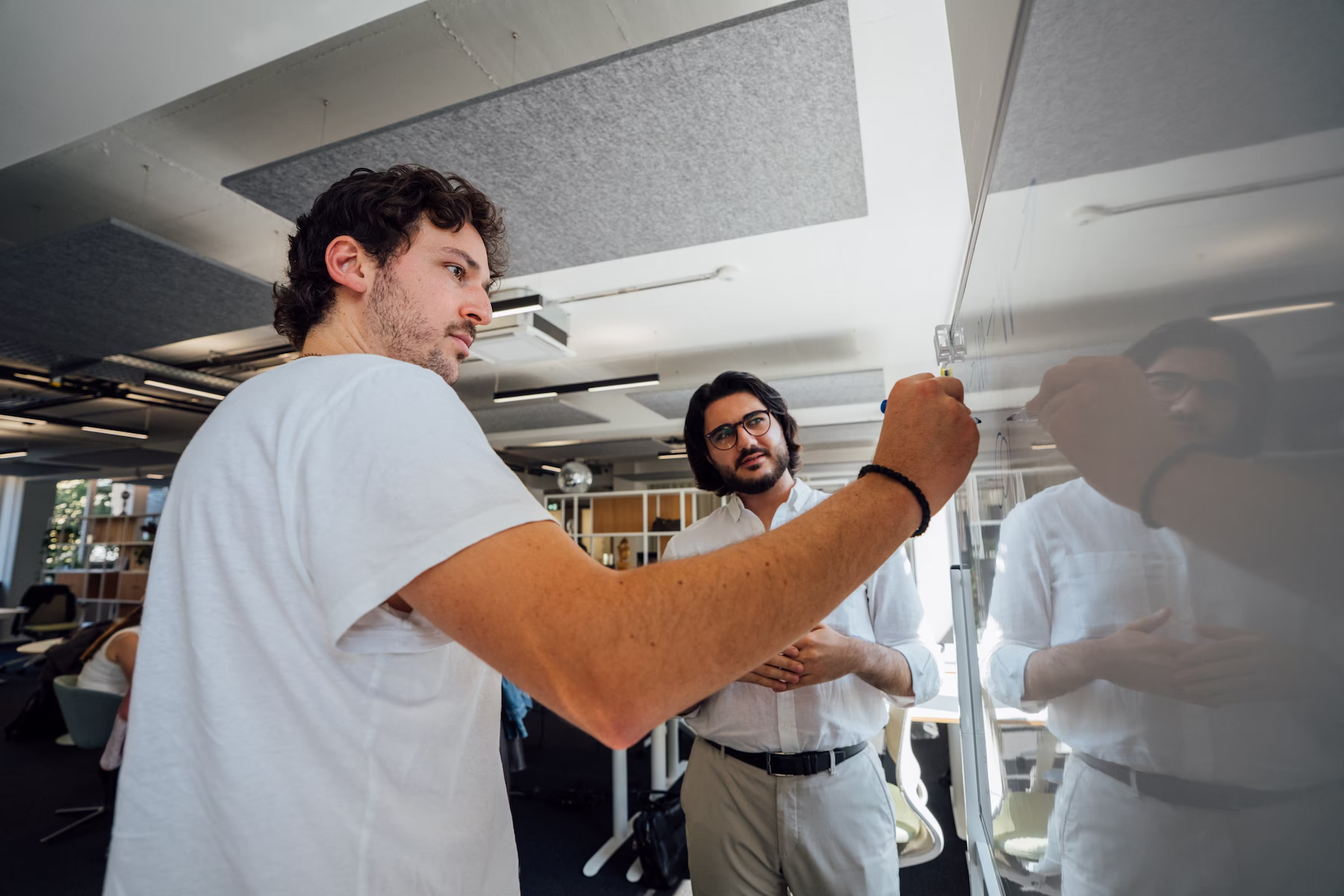 Zwei Mitarbeiter arbeiten gemeinsam an einer Installation im Büro