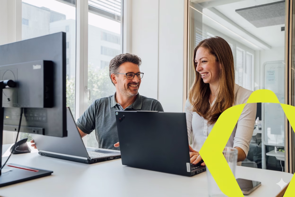 Zwei Personen arbeiten gemeinsam am Laptop im Büro