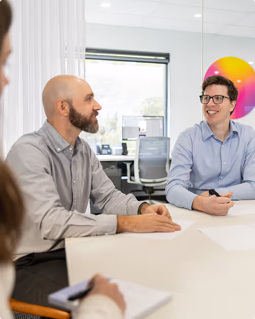Candid photo of a team engaged in a branding discussion around a table in a bright modern studio.