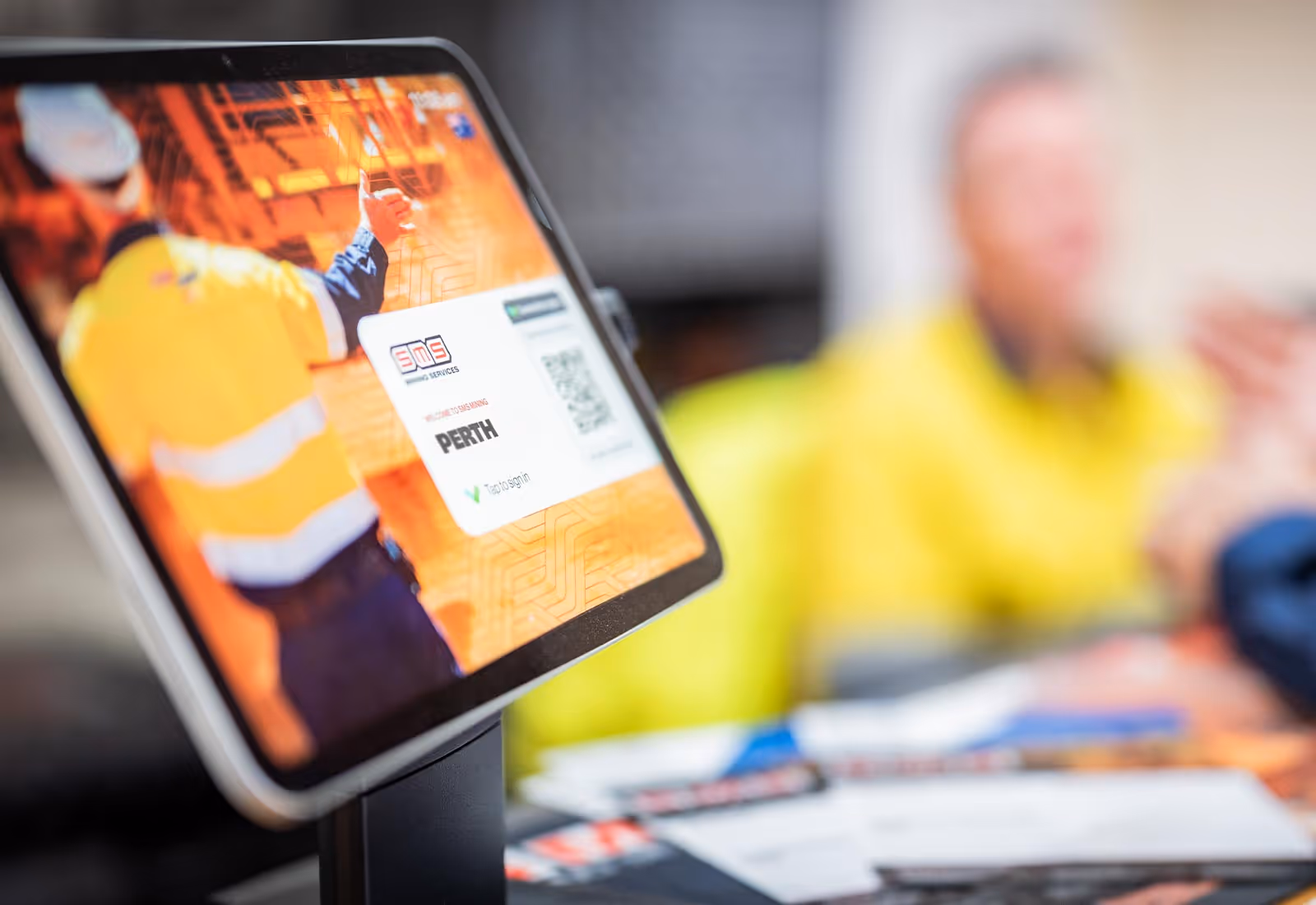 Tablet device at SMS Mining Services site displaying digital sign-in screen with Perth location and company branding.