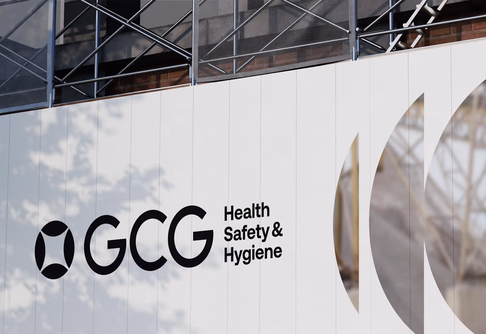Large exterior wall sign with GCG Health Safety & Hygiene logo in black on a white background