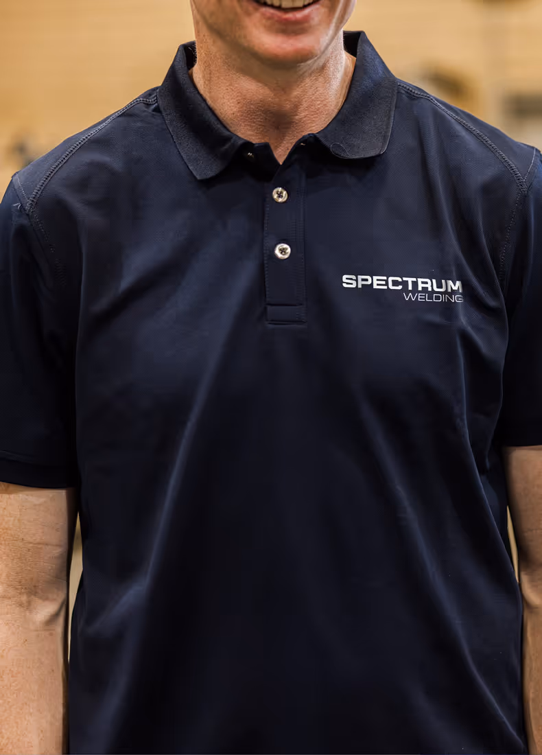 Man wearing navy Spectrum Welding branded polo shirt