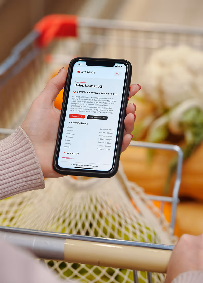 Close-up of a phone showing Coles Kelmscott store details inside a shopping trolley