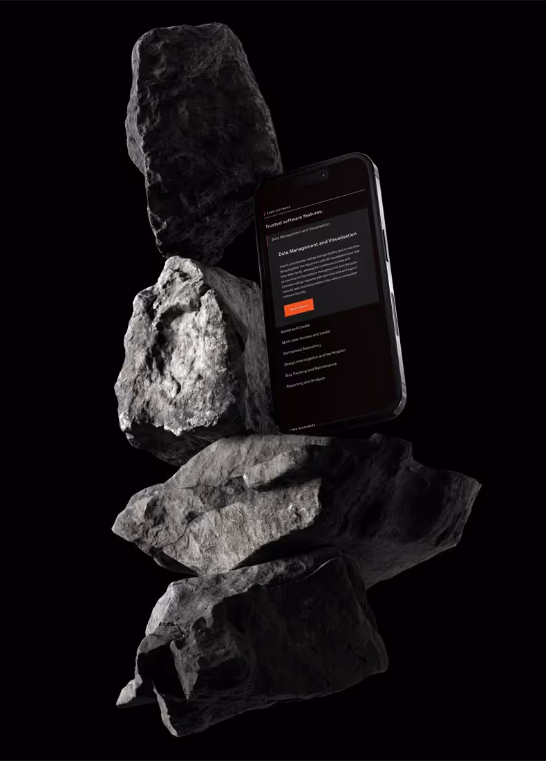 Phone displaying GDMS data management page, standing among stacked grey rocks on black background