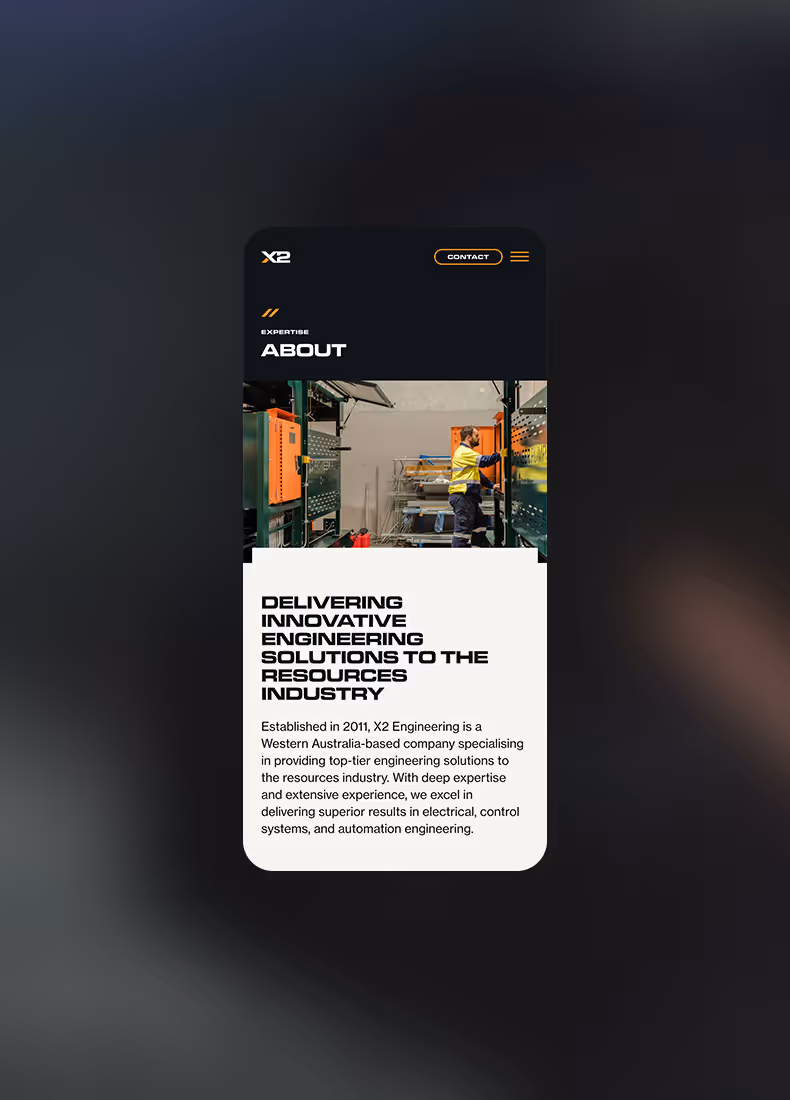 Mobile view of X2 Engineering’s About page with a worker in high-visibility clothing inside an industrial facility, accompanied by introductory text.