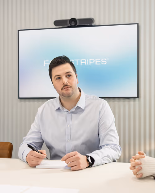 Candid photo of a team engaged in a branding discussion around a table in a bright modern studio.