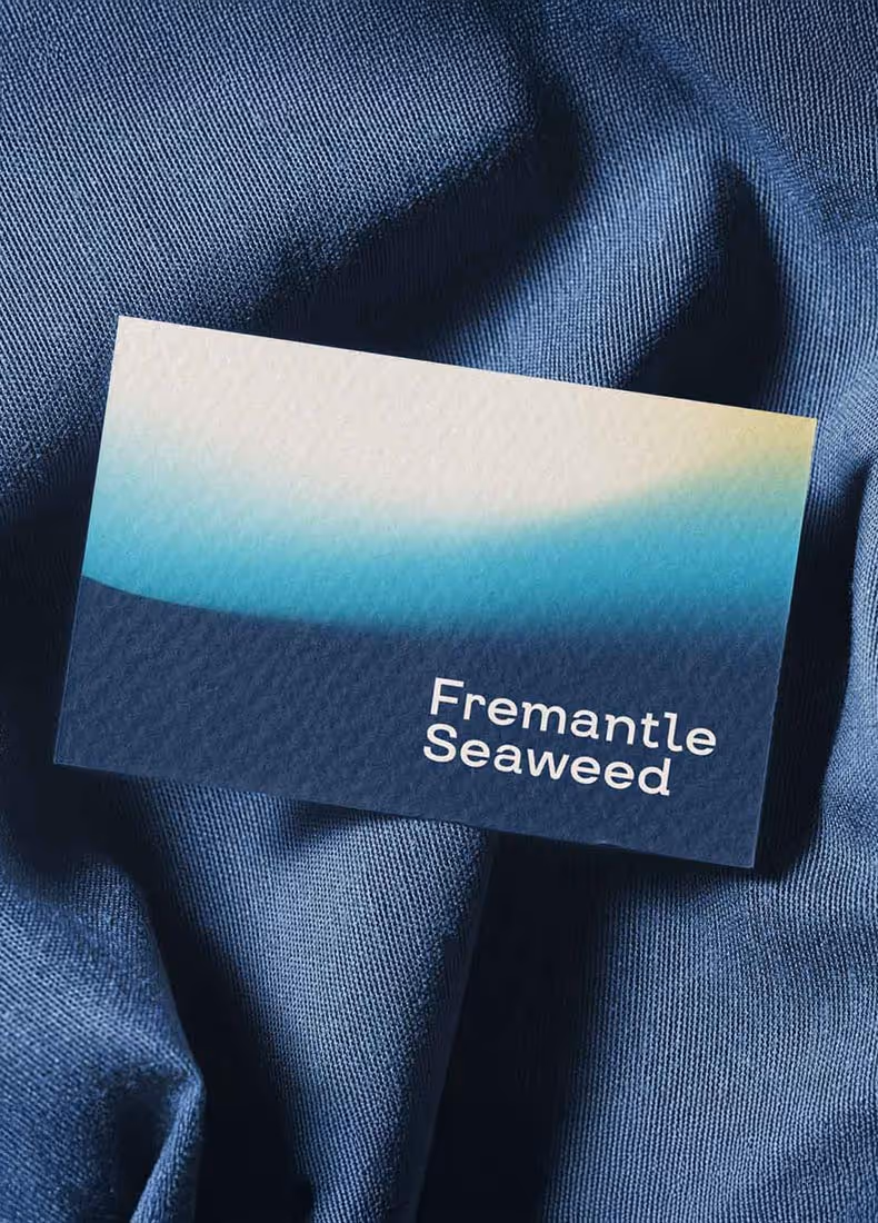 Fremantle Seaweed business card with gradient background on blue fabric.