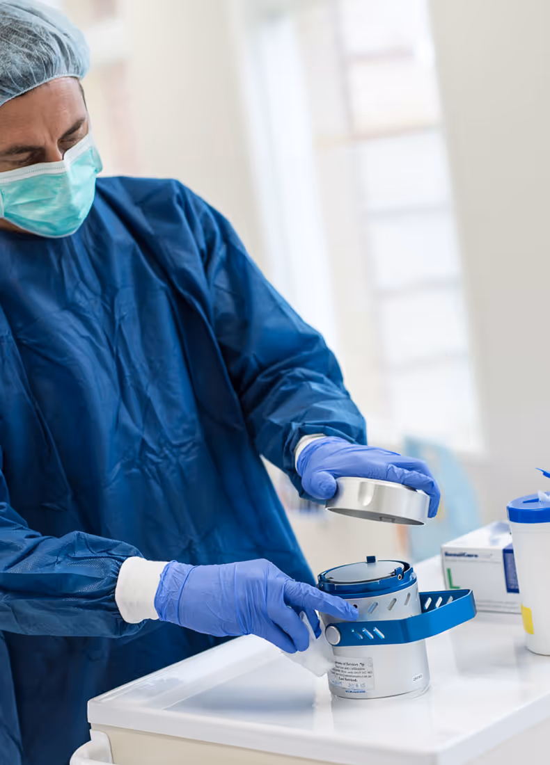 Lab technician in full PPE using sampling equipment, representing QED's expertise in workplace and environmental safety.
