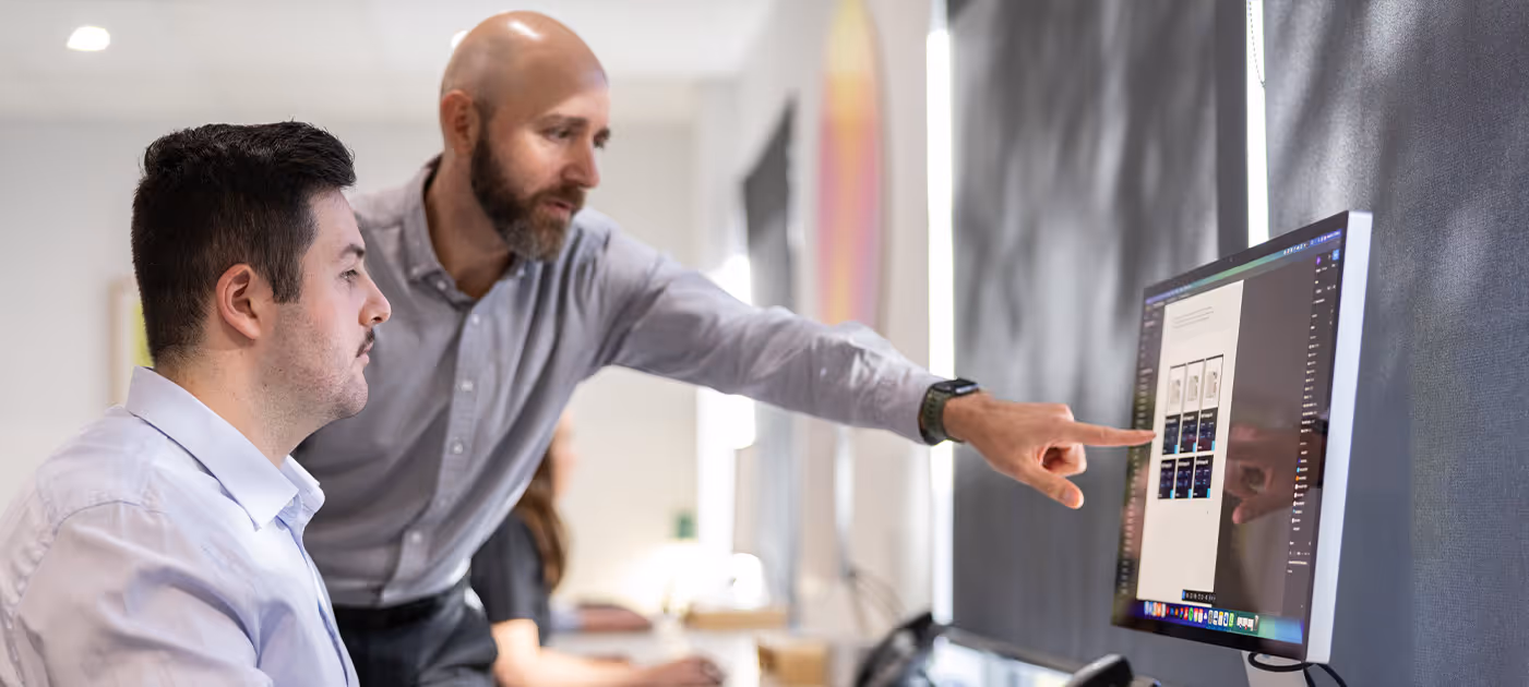 Team collaboration around desktop screens displaying live website interfaces and project workflows, capturing Four Stripes’ digital expertise in building responsive, strategic online platforms.