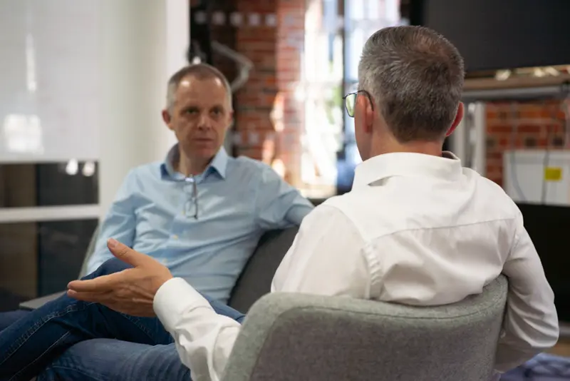 BCi digital team discussion: two employees, seated, in conversation