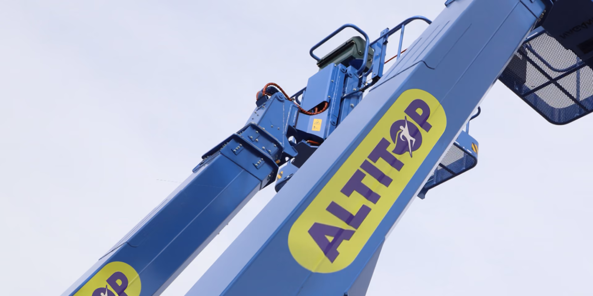 Branche d'élévateur bleu avec logo jaune et violet Altitop sur fond de ciel clair.