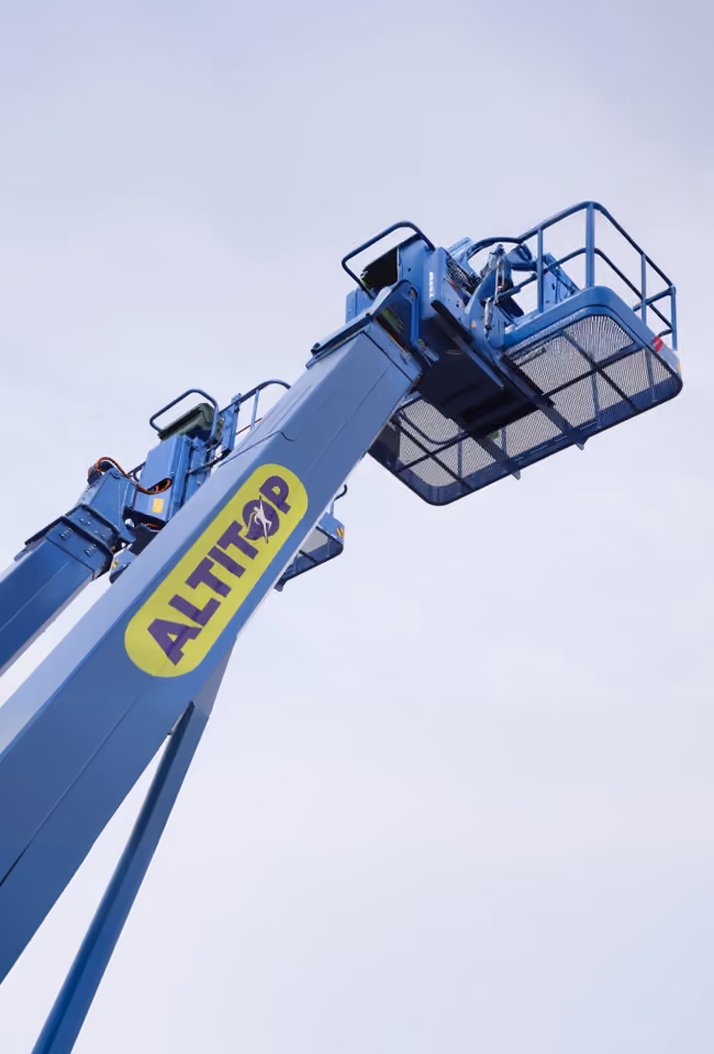 Plateforme élévatrice bleue Altitop avec nacelle vide en gros plan vue du sol.