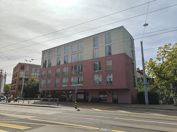 Modernes Mehrfamilienhaus mit Tramschienen davor