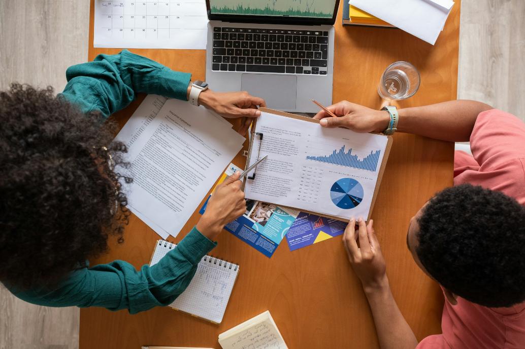 Menschen arbeiten gemeinsam an einem Tisch mit Notizen und Tablets