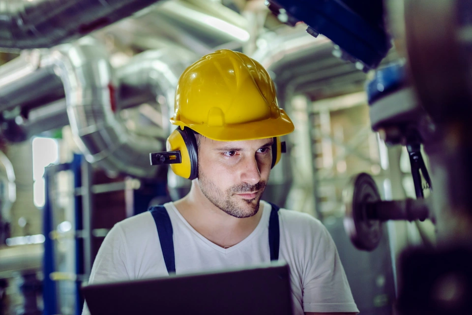 Ingenieur mit Schutzhelm und Schutzbrille arbeitet in einer Industrieanlage