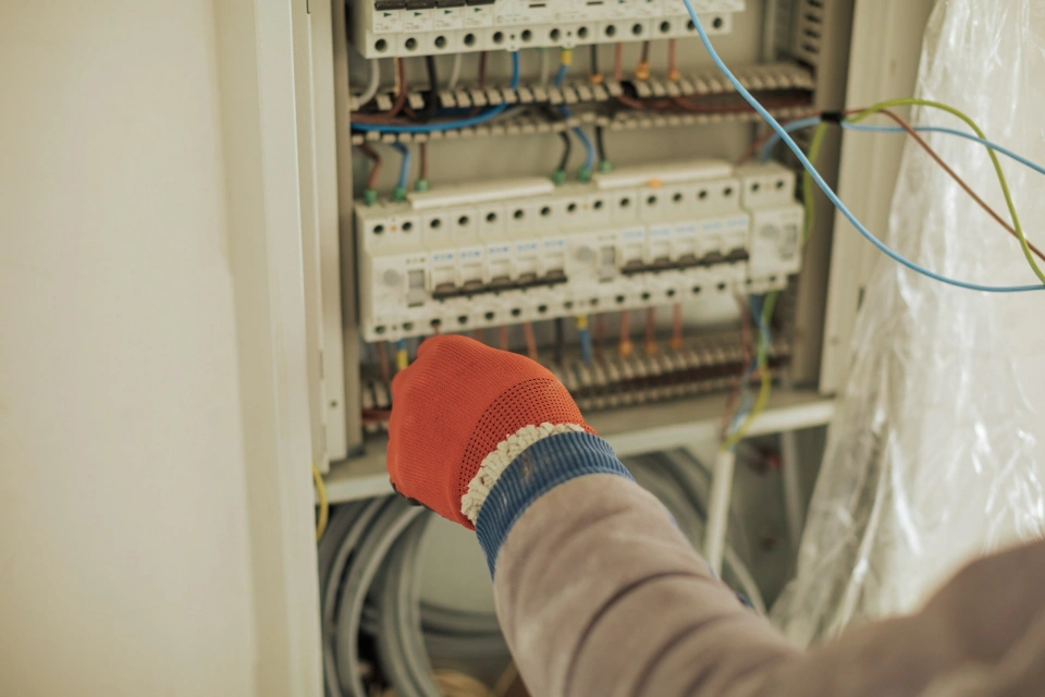 Techniker prüft Kabel und Elektrik im Schaltschrank