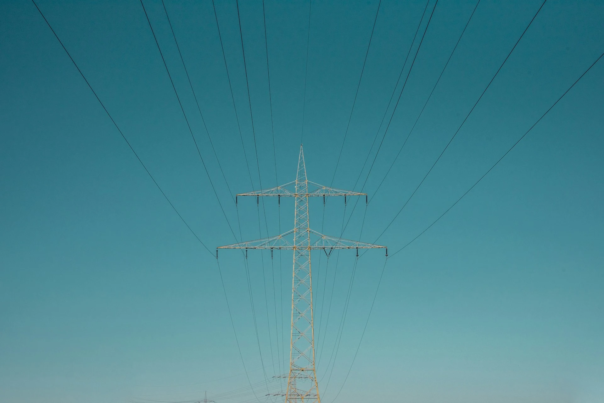Strommast vor blauem Himmel