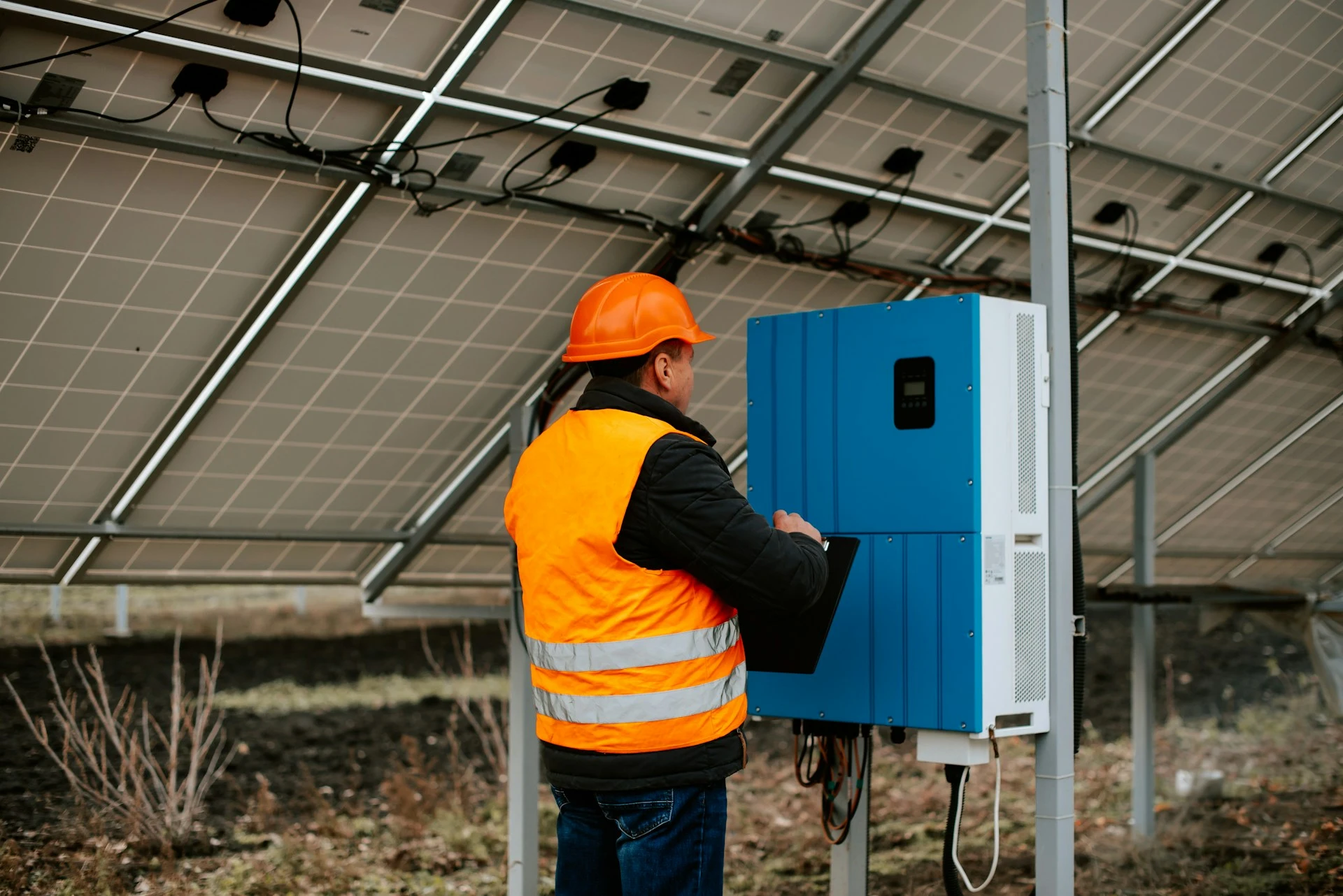 Arbeiter installiert elektrischen Schaltschrank auf Baustelle