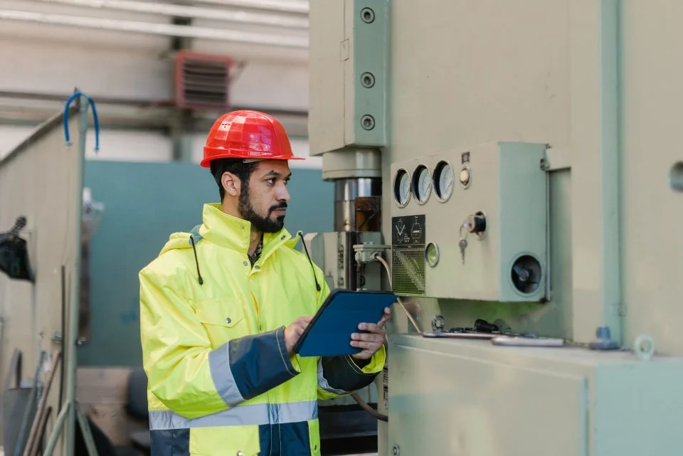 Ingenieur mit Helm überprüft industrielle Anlage