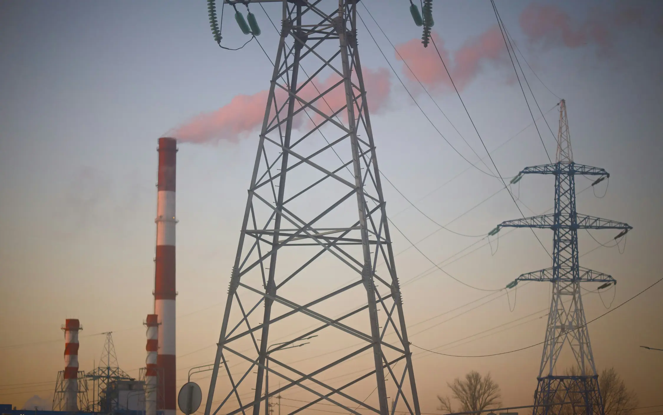 Strommast mit Hochspannungsleitungen bei Sonnenuntergang