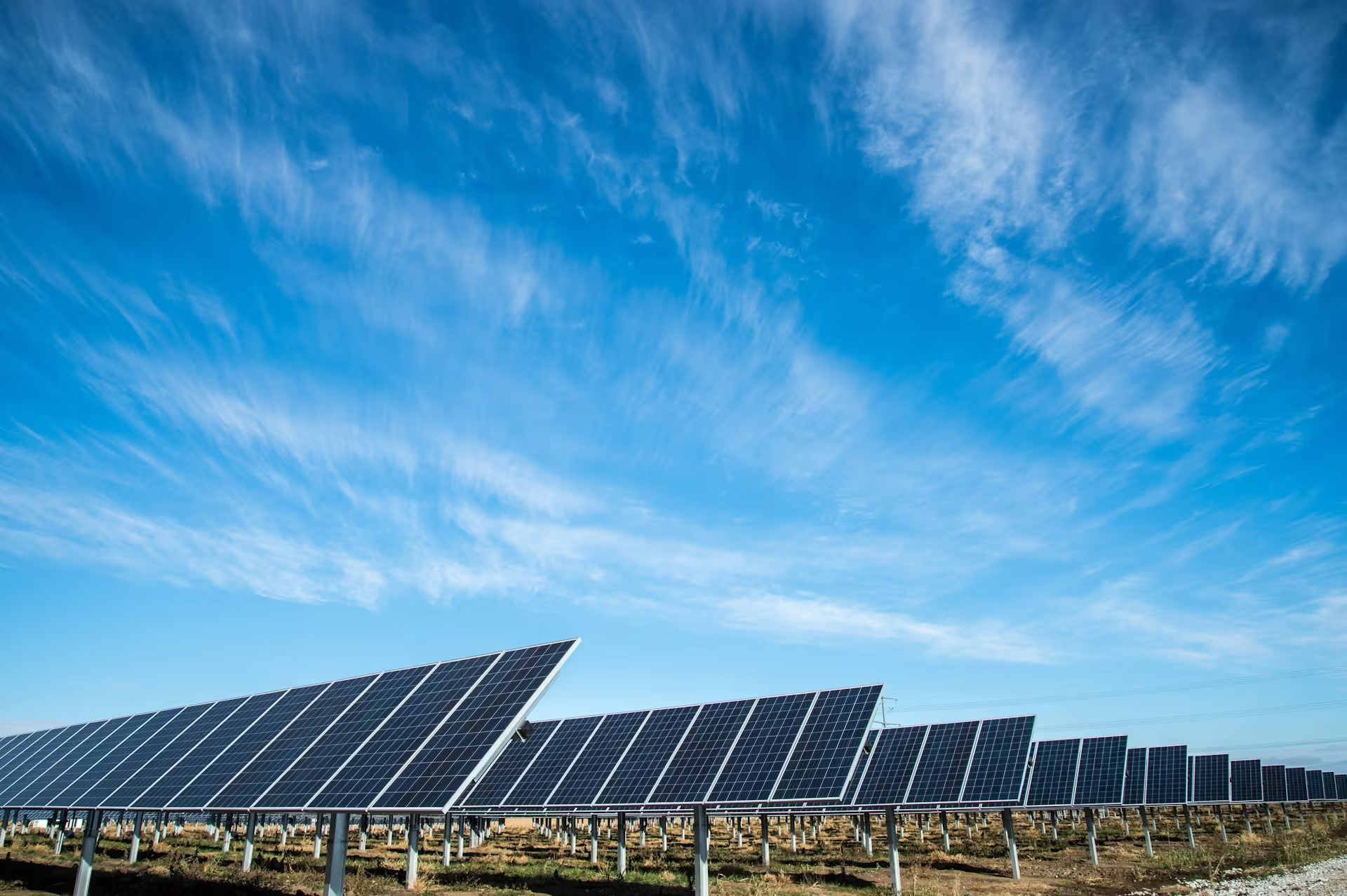Solarpanels auf einem Feld unter blauem Himmel mit Wolken