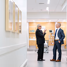 A doctor and patient discussion in hallway of medical clinic.
