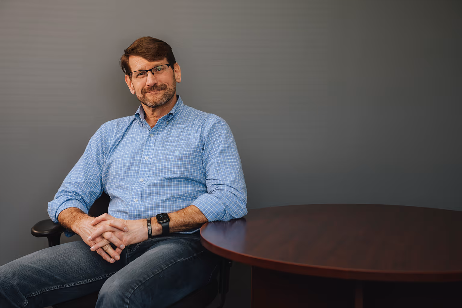 Tim Cesarek, CEO of Synata Bio, sitting in an office chair. 