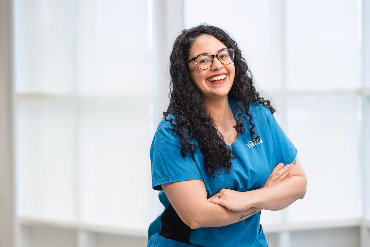 A patient care technician at DaVita smiles