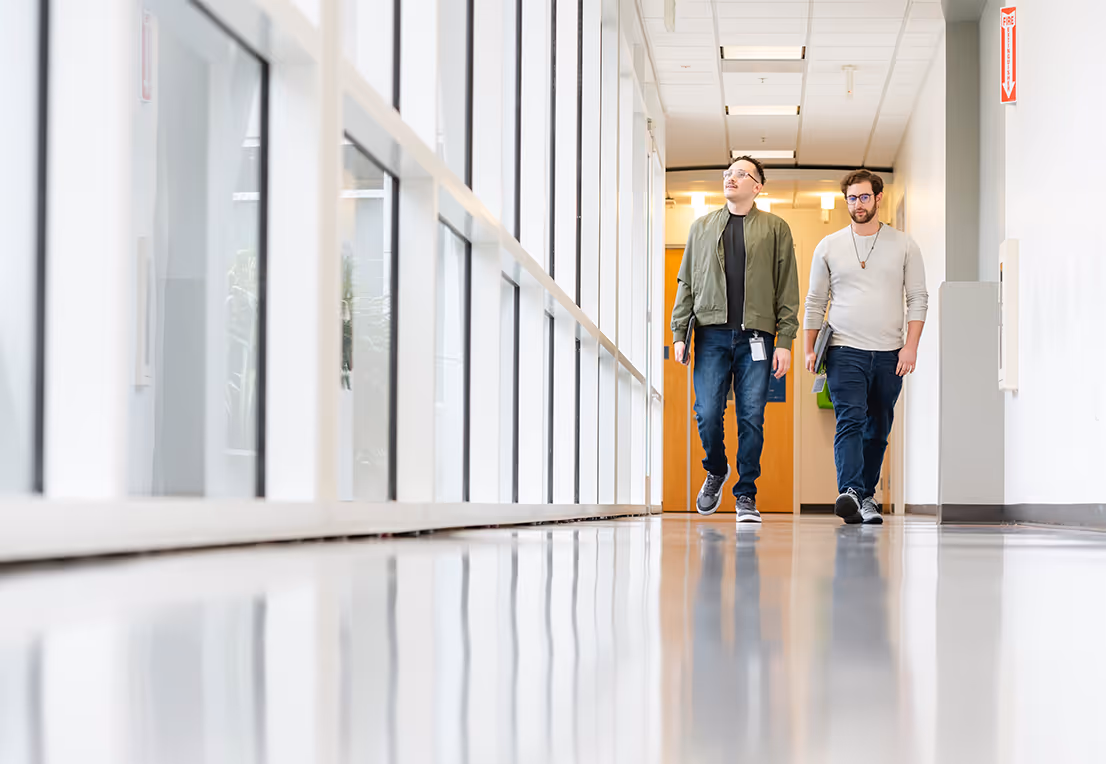 Two teammates walking through a hallway.