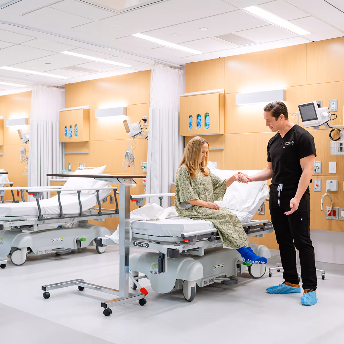 A patient is being helped out of a patient bed at DISC.
