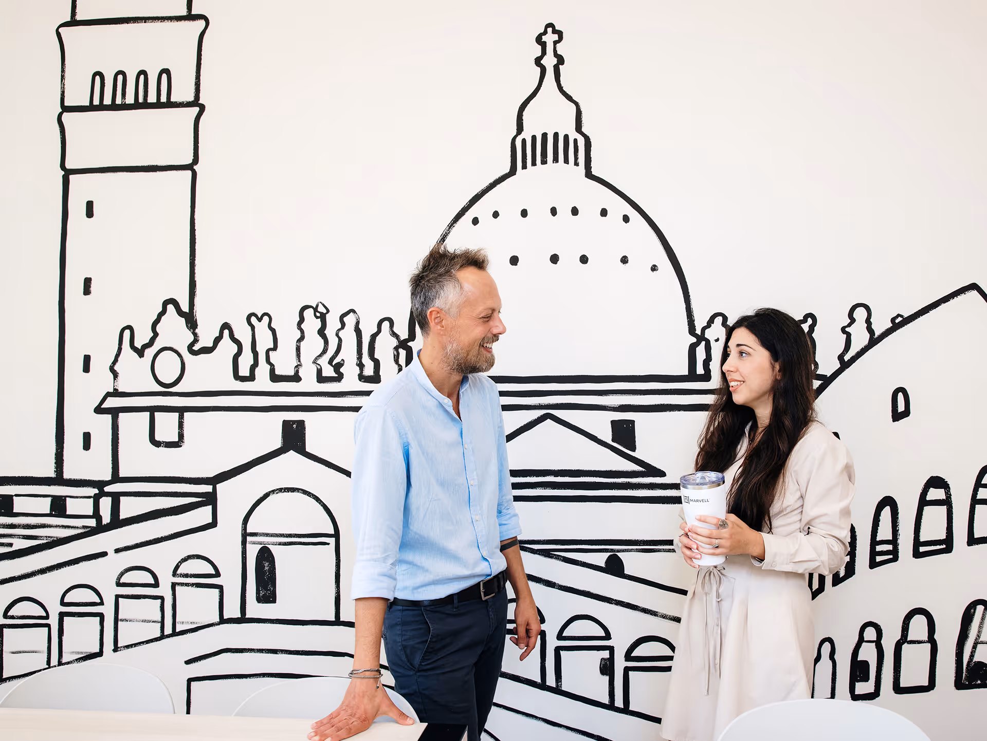 Marvell employees in Pavia, Italy in front of wall mural. 