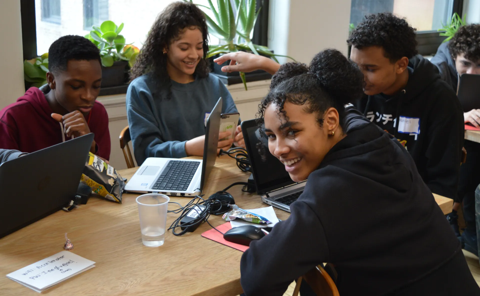 Students smiling and using computers.