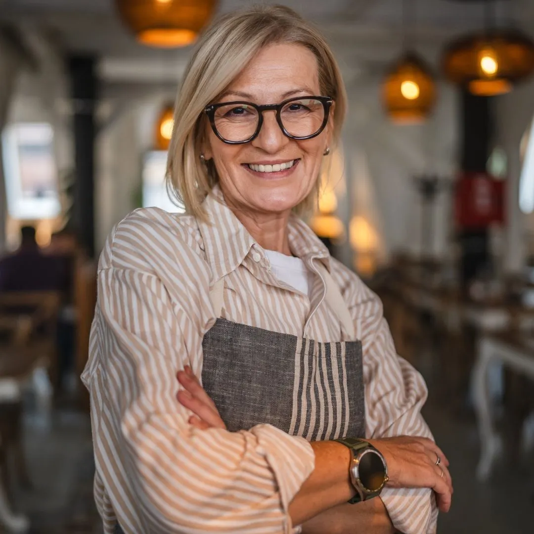 Lachende Frau mit Brille in einem Café.