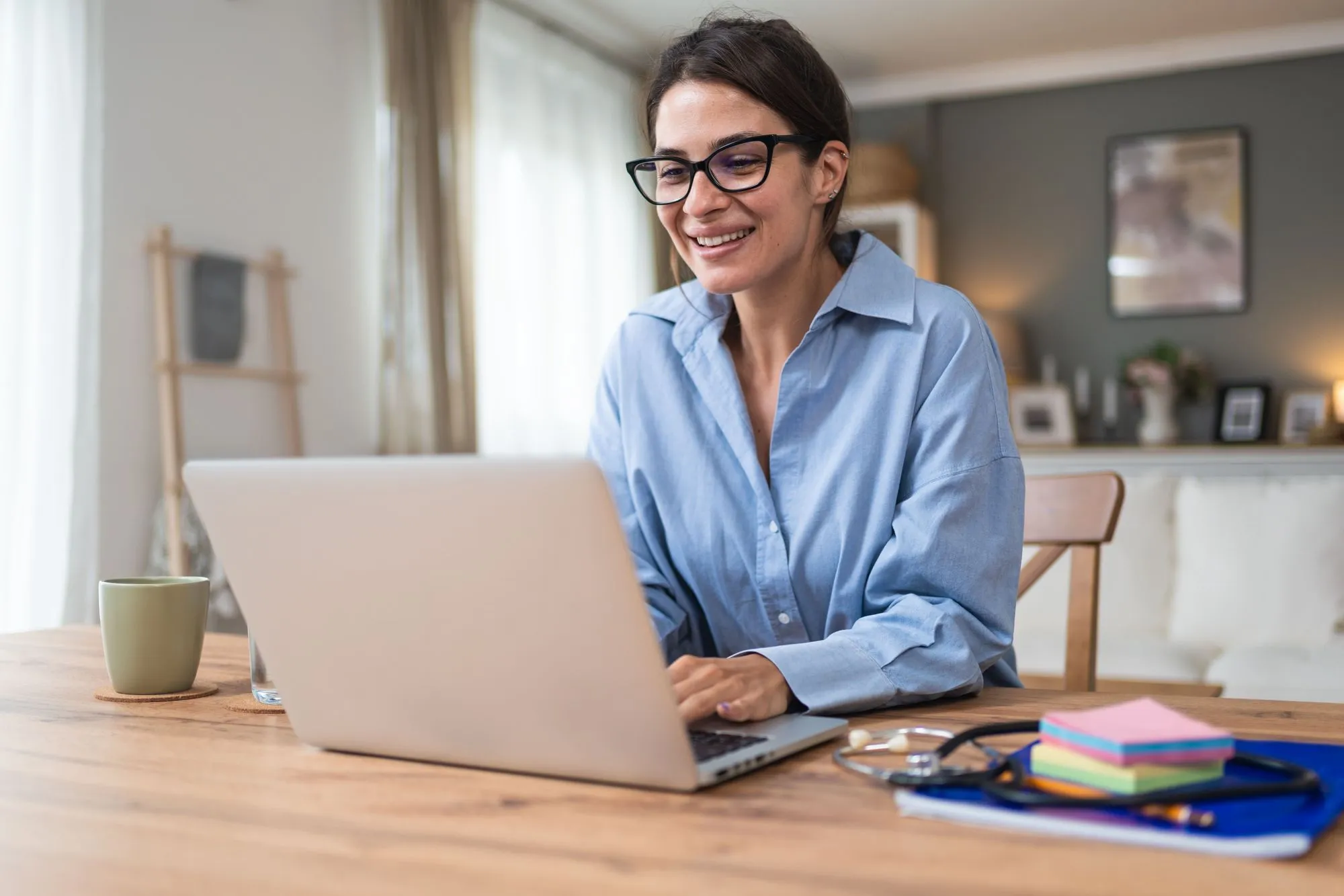 Frau arbeitet an einem Laptop in einem gemütlichen Homeoffice.
