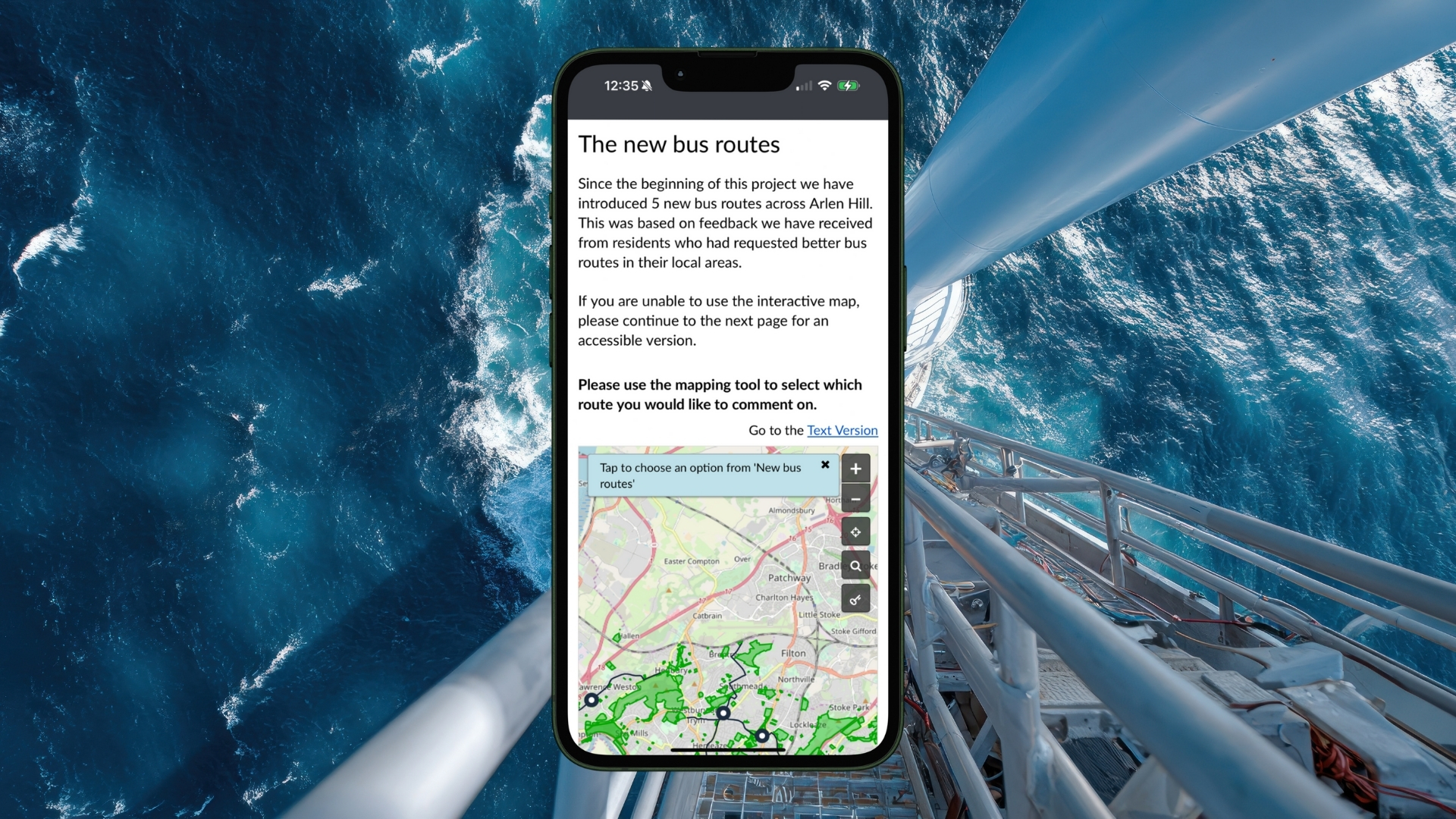 Smartphone screen displaying a webpage about new bus routes with an interactive map and instructions, set against a background view of ocean waves from a high offshore platform.