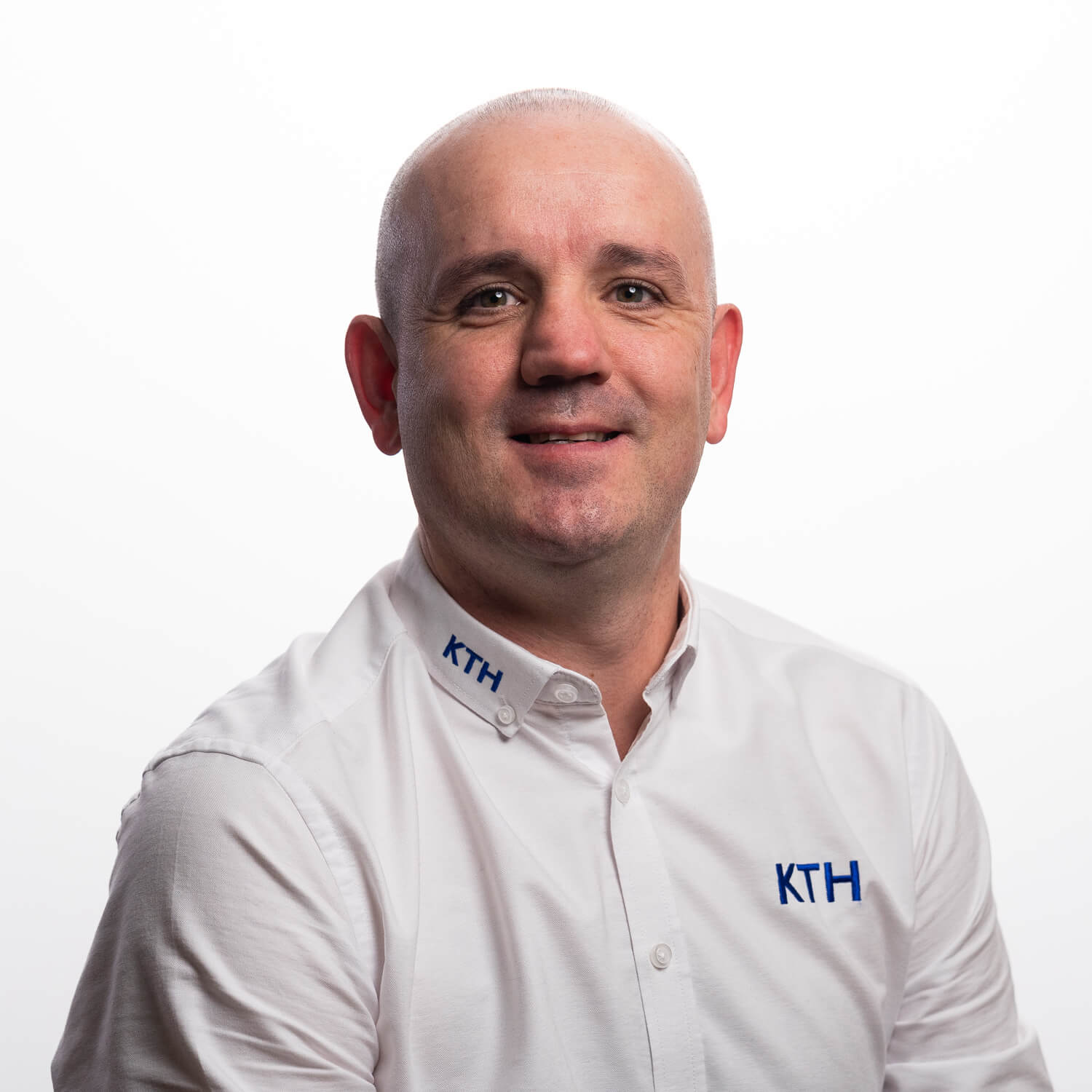 A portrait of Dean Holroyd on a white background in their work uniform