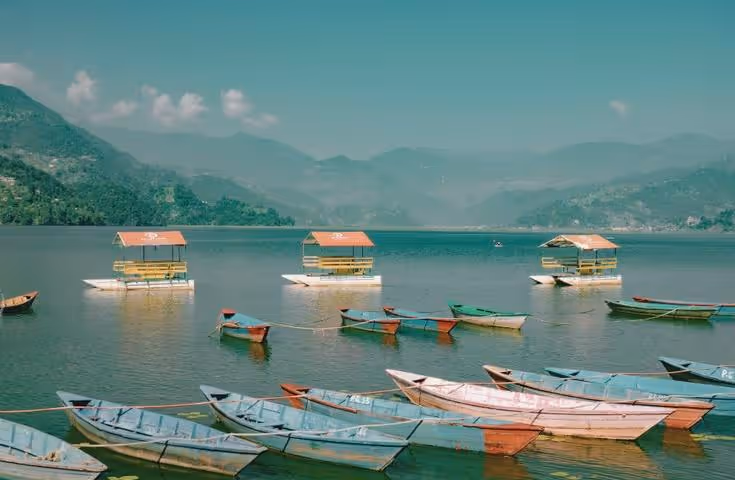 Barques colorées sur le lac de Pokhara avec vue sur l'Himalaya