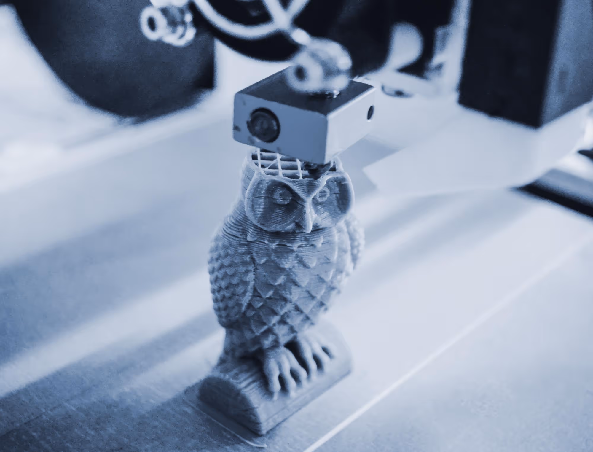 un buho de plastico siendo impreso en 3d