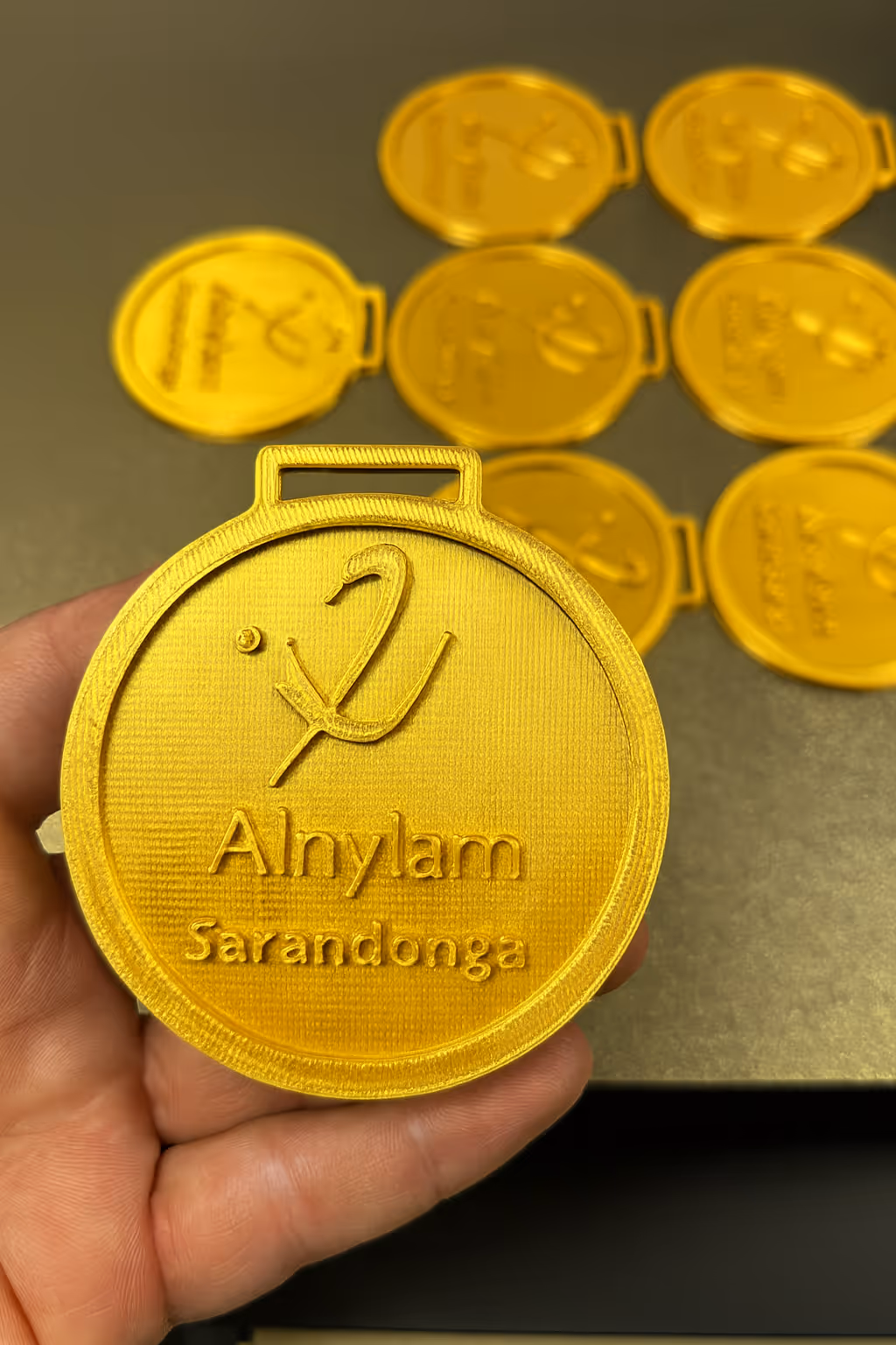 medalla color oro impresa en 3d con el logo de la empresa