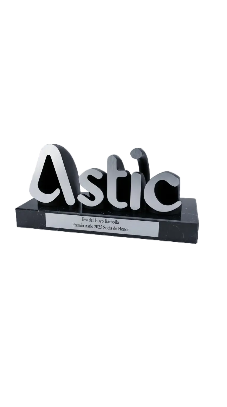 Trofeo con la palabra 'Astic' en letras plateadas sobre base negra de mármol con placa que dice Eva del Hoyo Barbolla, Premio Astic 2025 Socia de Honor.